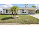Charming single-story home with well-manicured lawn and a lovely palm tree in the front yard at 6764 Stardust Ave, North Port, FL 34287