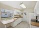 Bright kitchen features white cabinets, complementing countertops and a double sink beneath the window at 6764 Stardust Ave, North Port, FL 34287