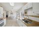 Open floor plan kitchen featuring tile floors, white cabinets, double sinks, and a dining area at 6764 Stardust Ave, North Port, FL 34287