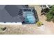 Aerial view of a screened-in pool area, roof, and surrounding landscape at 6794 Loffreda Ave, North Port, FL 34291