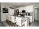 Modern kitchen with white cabinets, stainless appliances, and a stylish center island with seating at 6794 Loffreda Ave, North Port, FL 34291