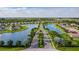 High-angle aerial view showcasing the community's layout with serene lakes, homes, and mature trees at 7292 Mikasa Dr, Punta Gorda, FL 33950