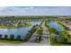 Expansive aerial view of a residential community with scenic lakes, fountains, and tree-lined streets at 7292 Mikasa Dr, Punta Gorda, FL 33950
