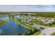 Aerial shot captures a picturesque community with a large lake, lush landscaping, and well-maintained homes at 7292 Mikasa Dr, Punta Gorda, FL 33950