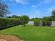 Spacious backyard featuring a pristine lawn, privacy fence, and mature trees creating a serene outdoor retreat at 7292 Mikasa Dr, Punta Gorda, FL 33950
