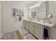 Bathroom featuring double sinks, framed mirrors, beach themed decor, shower with curtain, and wood look flooring at 7292 Mikasa Dr, Punta Gorda, FL 33950
