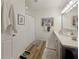 Bright bathroom with double vanity, framed mirrors, beach themed decor, shower with curtain, and wood look flooring at 7292 Mikasa Dr, Punta Gorda, FL 33950