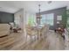 Formal dining area featuring gray accent wall, wood flooring, seating for six, modern light fixture, and large windows for natural light at 7292 Mikasa Dr, Punta Gorda, FL 33950
