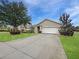 Well-maintained front yard featuring lush landscaping and a spacious driveway leading to a two-car garage at 7292 Mikasa Dr, Punta Gorda, FL 33950