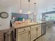 Open kitchen featuring an island, granite countertops, stainless steel appliances, and a view of the living room and dining area at 7292 Mikasa Dr, Punta Gorda, FL 33950