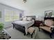 Bright main bedroom showcasing a large window, comfortable furnishings, neutral decor, and a cozy sitting area at 7292 Mikasa Dr, Punta Gorda, FL 33950