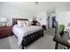 Spacious main bedroom featuring a dark wood bed frame, plush bedding, and access to ensuite bathroom and walk-in closet at 7292 Mikasa Dr, Punta Gorda, FL 33950
