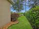 Lush side yard with vibrant greenery, decorative rocks, and a well-maintained lawn creating a tranquil outdoor space at 7292 Mikasa Dr, Punta Gorda, FL 33950