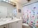 Bright bathroom with white vanity, floral shower curtain, and modern fixtures at 1007 Comstock St, Port Charlotte, FL 33952