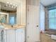 Bathroom boasts stylish wallpaper, a soaking tub, and a spacious vanity area at 1007 Comstock St, Port Charlotte, FL 33952