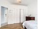 Bright bedroom featuring wood floors, bi-fold closet doors, and a decorative wooden dresser at 1007 Comstock St, Port Charlotte, FL 33952