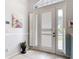 Bright foyer featuring tile flooring, and white doors with windows and shutters that let in natural light at 1007 Comstock St, Port Charlotte, FL 33952