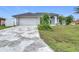 Charming single-story home with a two car garage, neutral paint, and a patterned concrete driveway at 1007 Comstock St, Port Charlotte, FL 33952