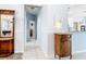 Inviting hallway featuring tile flooring, soft blue walls, and decorative wooden furnishings at 1007 Comstock St, Port Charlotte, FL 33952