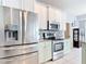 Kitchen featuring stainless steel appliances, light green cabinets, granite countertops and a tiled backsplash at 1007 Comstock St, Port Charlotte, FL 33952