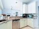 Kitchen featuring granite countertops, stainless steel appliances, light green cabinets and an open view to the living room at 1007 Comstock St, Port Charlotte, FL 33952