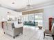 Open concept living room features tile floors, tray ceilings, fan, and seamless access to the outdoors at 1007 Comstock St, Port Charlotte, FL 33952