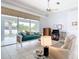Bright living room with tile floors, light blue walls, fan, large window, and casual seating at 1007 Comstock St, Port Charlotte, FL 33952