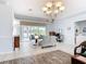 Bright living room with tile floors, a decorative chandelier and sliding glass doors leading to an outdoor seating area at 1007 Comstock St, Port Charlotte, FL 33952