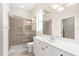 Bathroom with glass enclosed shower, toilet, and white vanity with plenty of lighting at 10316 Hebblewhite, Englewood, FL 34223