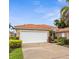 Charming single-story home with a red tile roof, two-car garage, and well-maintained landscaping at 10316 Hebblewhite, Englewood, FL 34223