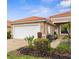 Beautiful single-story home with a red tile roof, well-manicured landscaping, and a two-car garage at 10316 Hebblewhite, Englewood, FL 34223