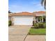 Inviting single-story home featuring a red tile roof, a two-car garage, and lush front yard at 10316 Hebblewhite, Englewood, FL 34223