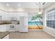 Bright kitchen with white appliances, countertops, and a mural with a beach theme at 10316 Hebblewhite, Englewood, FL 34223