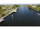 Wide canal view with several docks, solar panels, and well-manicured tropical landscaping at 107 Sinclair Se St, Port Charlotte, FL 33952