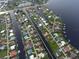 Aerial view of canal-front homes showcasing the community's layout and waterway access, with boats in the canal at 107 Sinclair Se St, Port Charlotte, FL 33952