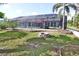 The backyard features a screened-in pool, patio, a fire pit, and well-maintained lawn, perfect for outdoor enjoyment at 107 Sinclair Se St, Port Charlotte, FL 33952
