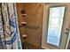 Accessible shower with grab bars, tiled walls, shelves, and a glass door providing access to the outside at 107 Sinclair Se St, Port Charlotte, FL 33952