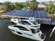 Aerial view of boat dock with solar panels, shading boat and providing sustainable energy at 107 Sinclair Se St, Port Charlotte, FL 33952