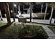 Illuminated covered boat lift at night, surrounded by lush foliage and a stone path at 107 Sinclair Se St, Port Charlotte, FL 33952