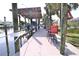 Spacious dock with solar panels above the boat lift and red seating area near the water at 107 Sinclair Se St, Port Charlotte, FL 33952