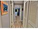 Bright hallway features wood floors, closet doors, and wall decor, leading into the home at 107 Sinclair Se St, Port Charlotte, FL 33952