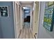 Hallway with wood floors leading to an office space, enhanced by natural light and storage at 107 Sinclair Se St, Port Charlotte, FL 33952