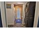 Hallway showing stacked washer/dryer across from bathroom entrance with tiled floor and natural light at 107 Sinclair Se St, Port Charlotte, FL 33952