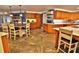Open-concept kitchen featuring custom cabinetry, tile flooring, a spacious island, and a breakfast bar at 107 Sinclair Se St, Port Charlotte, FL 33952