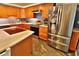 Modern kitchen with wood cabinets, stone countertops, stainless steel refrigerator, and stone tile floors at 107 Sinclair Se St, Port Charlotte, FL 33952