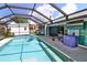 Enclosed pool area with pool, barbecue, TV, and shed, offering a complete outdoor entertainment space at 107 Sinclair Se St, Port Charlotte, FL 33952