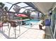 A covered pool area with a large pool, seating, and open design for outdoor enjoyment at 107 Sinclair Se St, Port Charlotte, FL 33952