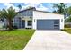 Modern home with a two-tone color scheme, palm trees, and well-manicured lawn at 14179 Massey Ave, Port Charlotte, FL 33953