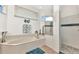 Bright bathroom featuring soaking tub and glass enclosed shower with beach themed decor at 1499 Nuremberg Blvd, Punta Gorda, FL 33983