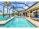Inviting screened pool features a brick paver surround, in-ground pool, and an outdoor lounge area at 1499 Nuremberg Blvd, Punta Gorda, FL 33983